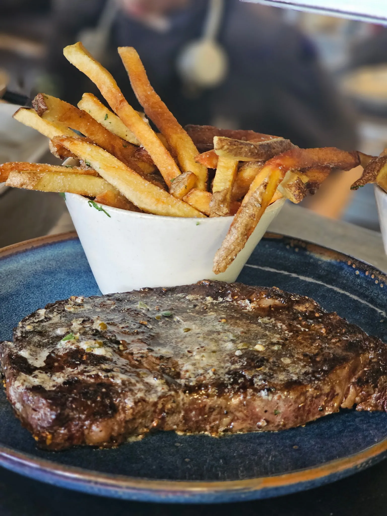 Wood-fired Alberta steak with notable steak butter and house-cut fries at our Montgomery Calgary steakhouse