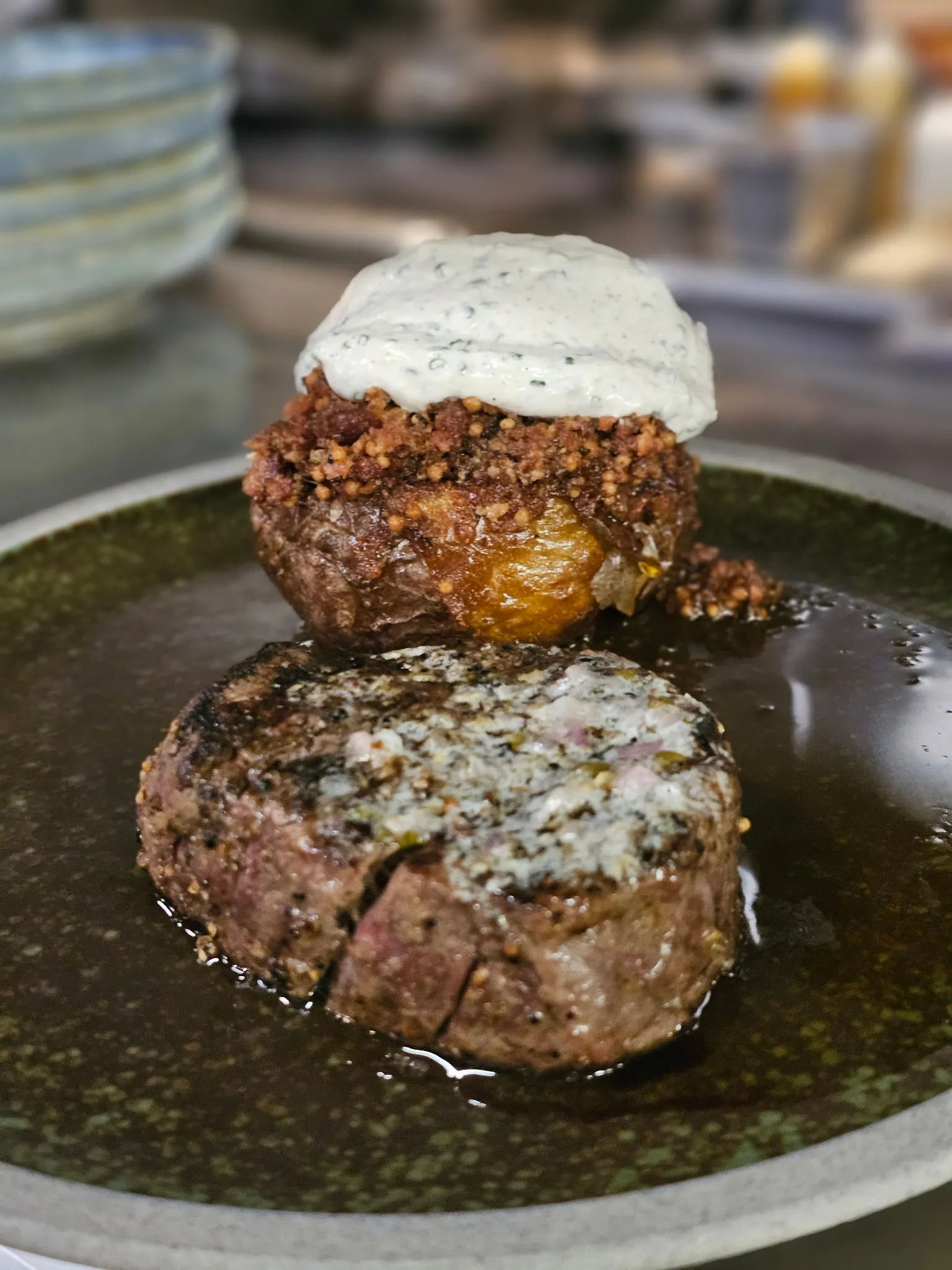 Hand-cut Alberta steak with notable steak butter, served with a tallow-cooked baked potato and spiced local sour cream in Calgary