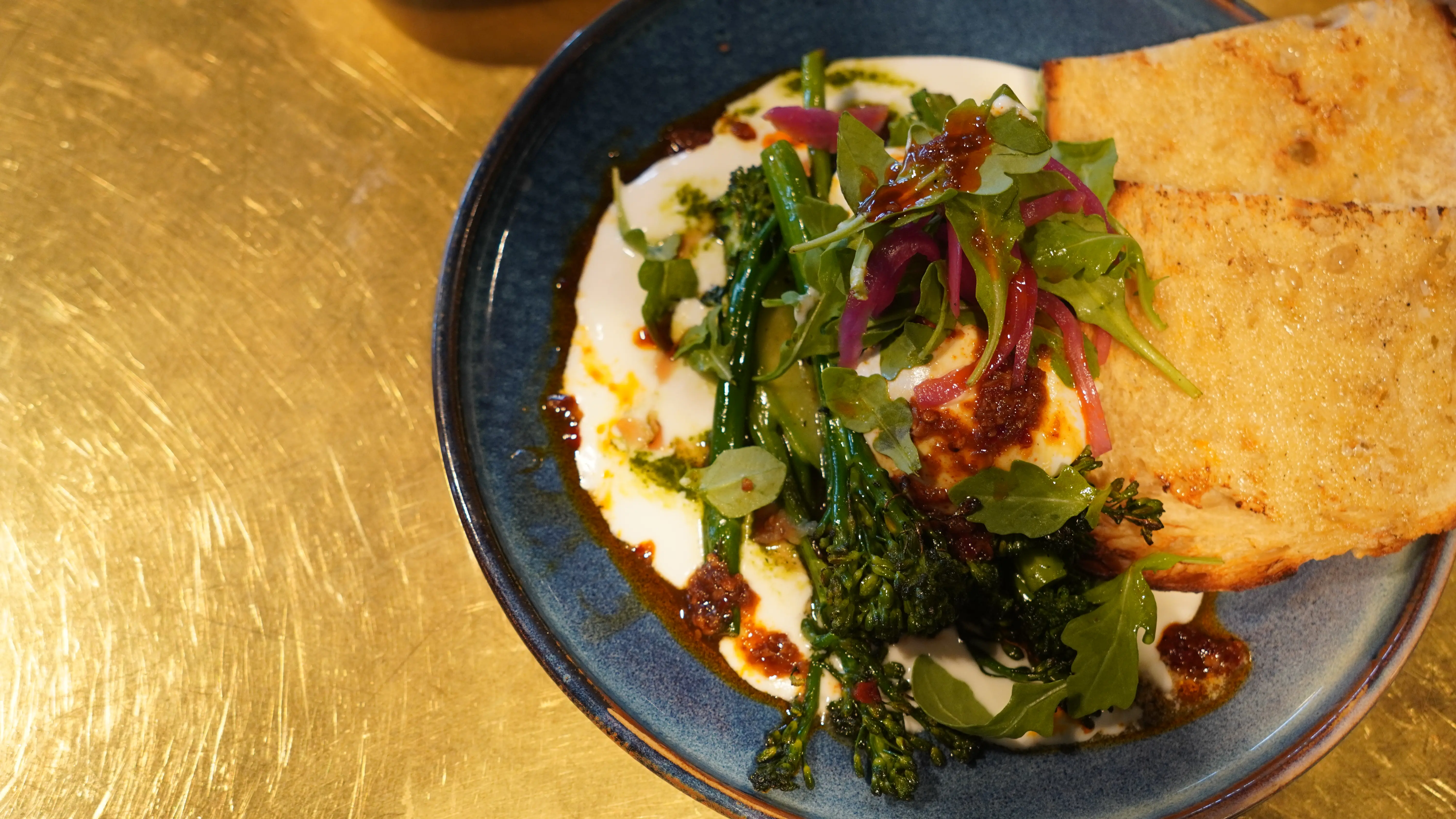 Charred broccolini with whipped ricotta, chilli crisp and grilled flatbread at notable - The Steakhouse in northwest Calgary