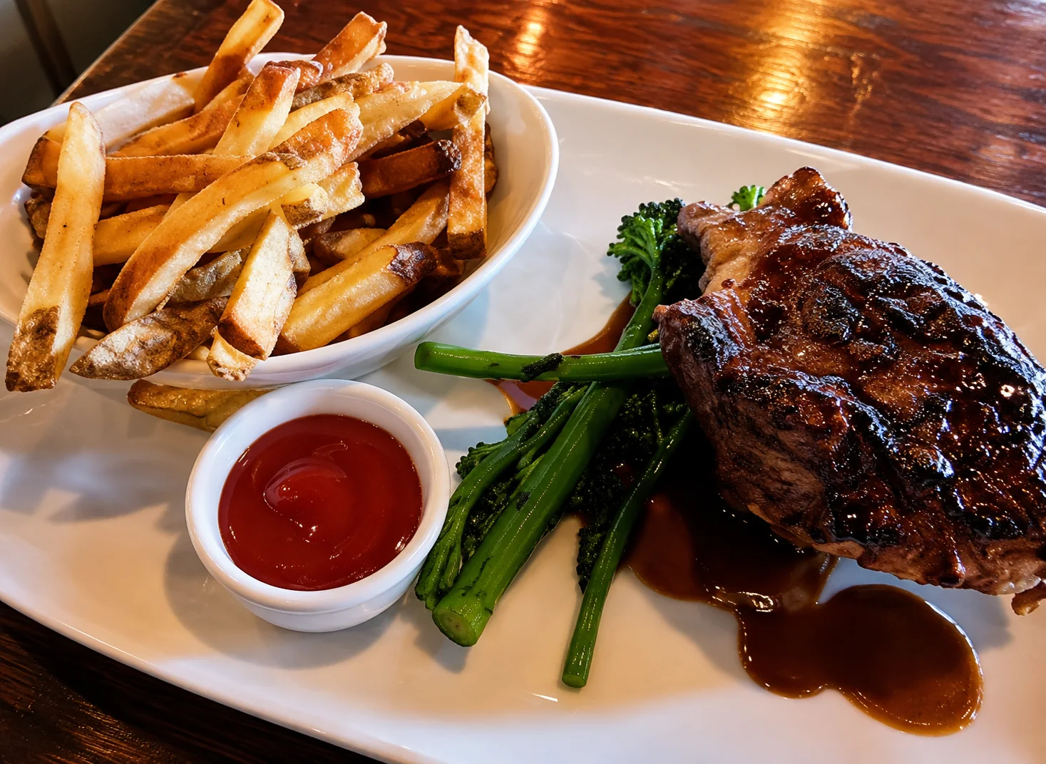 Wood-fired steak with house-cut fries and broccolini, served at lunch at notable - The Steakhouse in Montgomery, Calgary